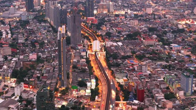 BTS Skytrain moving from station above Krung Thon Buri Road in Bangkok at night