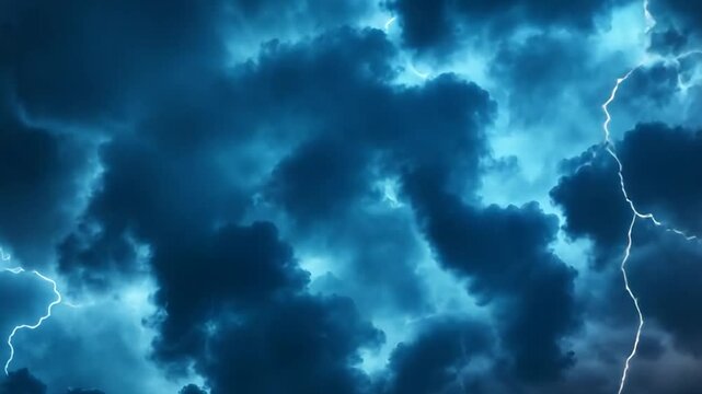 Dramatic thunderstorm clouds illuminated by lightning over a darkened landscape at night