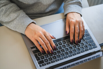 close up on female hands type on laptop keyboard