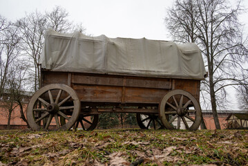 Vintage covered wagon on grassy field.
