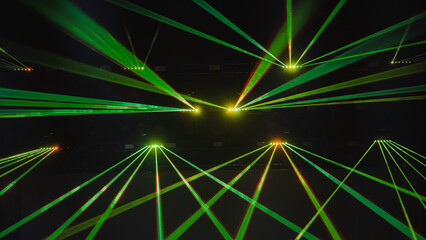 Green laser lights illuminating dark concert hall during music festival