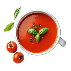 A top view of tomato soup in a white bowl garnished with basil and tomatoes nearby