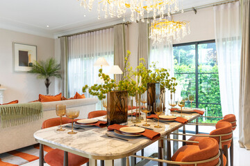 Beautiful luxurious traditional style modern dining room with bouquets of flowers on the table. Elegance dinning table with luxurious pendant.