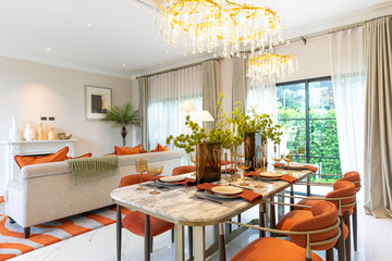 Beautiful luxurious traditional style modern dining room with bouquets of flowers on the table. Elegance dinning table with luxurious pendant.