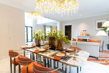 Beautiful luxurious traditional style modern dining room with bouquets of flowers on the table. Elegance dinning table with luxurious pendant.