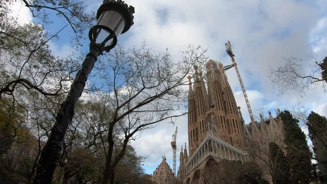 A stunning view of a famous architectural monument in the midst of nature, showcasing its unique design and the progress of construction. The scene blends natural beauty with elements of human creativ