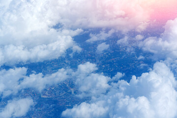 Fluffy clouds as seen through, beautiful cloudy sky and city down © aapsky