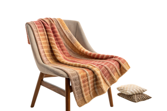 Elegant beige chair draped in a striped knit blanket with warm earth tones, two cushions nearby, isolated on a transparent background - Powered by Adobe