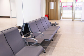 Empty Chairs brown for passengers waiting at airport lounge area station room.  Light shines through glass window. Modern interior design for tourists to travel around. Modern design to serve public.