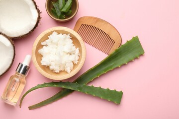 Hair treatment. Coconut butter, cosmetic product, comb and aloe leaves on pink background, flat lay