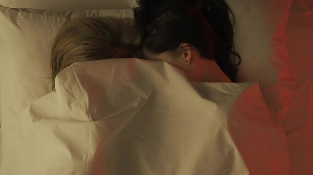 Top view young loving couple romantic time in bedroom. Man and woman half naked sensual lovers laying in bed together, passion, intimacy kissing, foreplay and bonding.