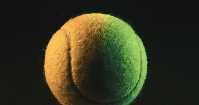 Close-up of a Tennis Ball under Studio Lighting. High-quality close-up shot of a tennis ball illuminated with dramatic studio lighting on a dark background. Sport, tennis, focus, competition, training