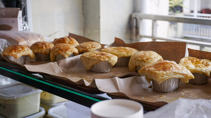 Golden brown and perfectly glossy, a fresh line of zuppa soup pastries rest on wax paper, their flaky crusts still warm crisp, inviting, and ready to steal the spotlight.