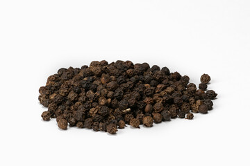 Heap of hot black peppercorns on white background. Isolated