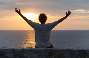 Fototapeta premium At the edge of the mountain, a sense of inspiration and hope washes over the young man as he looks out to the rising sun