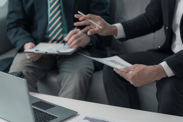 Close up of hands of business team during discussion. Financial charts and graphs on the table....