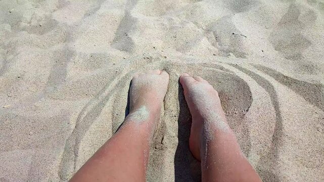 Person enjoying sand on beach. White skinned man burying bare feet in sand on beach on hot sunny summer day. Concept relaxation vacation holiday travel rest recreation tourism touch