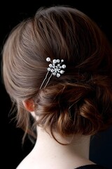 Naklejka premium A brunette bride's hairstyle features a bun adorned with beads and trimmed with hair clippers
