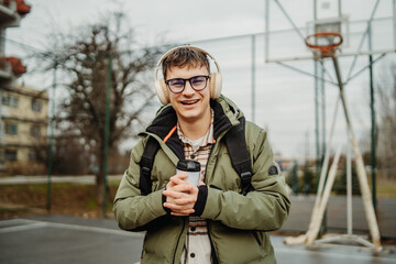 Portrait of a young man student smiling on a university basketball court
