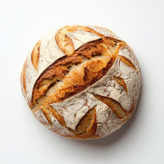 An overhead shot of a loaf of sourdough bread with decorative cuts on a white surface