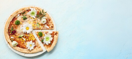 Pizza with beautiful flowers on light blue background with space for text, top view