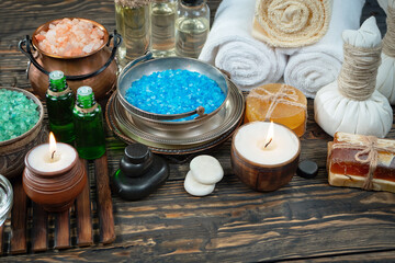 Spa treatment with candles and towel on wooden table, closeup