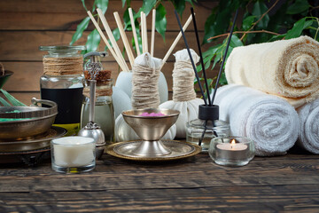 Spa treatment with candles and towel on wooden table, closeup