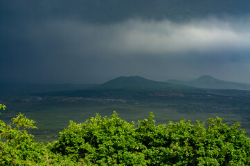 Dark sky with black clouds accumulated in the mountains foreshadowing heavy precipitation in the form of rain. An impending heavy rain or storm. The danger of being in the mountains on a rainy day