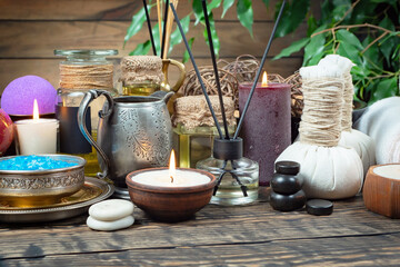 Spa treatment with candles and towel on wooden table, closeup