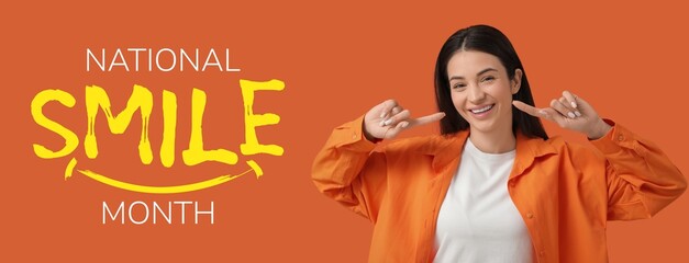 Beautiful happy young woman pointing at her teeth on orange background. Banner for National Smile Month