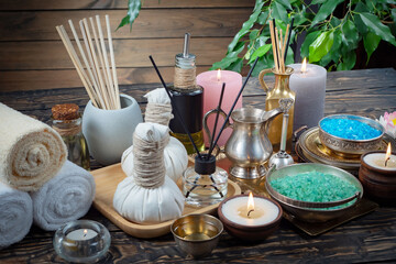 Spa treatment with candles and towel on wooden table, closeup