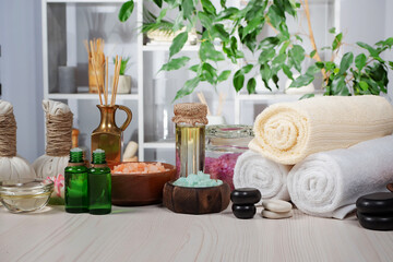 Spa treatment with candles and towel on wooden table, closeup