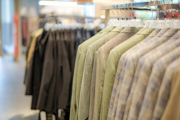 Obraz premium Stylish blazers hung on display in a modern clothing store during daylight hours showcasing a variety of fabrics and colors