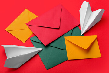 Set of different envelopes and paper planes on red background