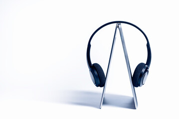 Wireless headphones are worn on thin laptop. Powerful duet for complete immersion in virtual worlds.
