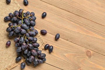 Sweet black grapes on wooden background