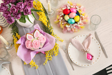 Beautiful Easter table setting with spring flowers, Easter cake and painted eggs