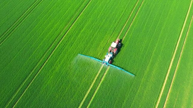 Pesticide  aplication. A tractor with chemical sprayer working on a field.