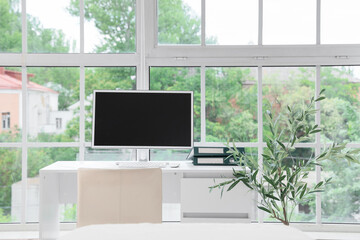 Doctor's workplace with blank computer monitor and folders in medical office