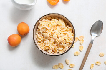 Apricots and bowl with cornflakes on white background, closeup