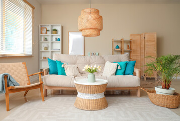 Interior of beautiful living room with comfortable sofa, coffee table, armchair and lamp