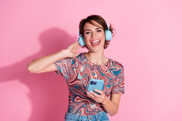Photo of lovely positive cheerful girl wear trendy print clothes hold device isolated on pink color...