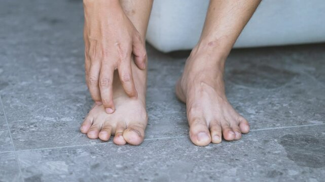 man hand scratch feet, itch foot, problem itchy skin on carpet at home, dermatitis from fungus, fungal bacterial infection, allergic reaction, eczema. Foot care concept