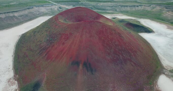 A drone shot looking back across Lake Meke. The striking conical structure at the centre of the crater and the vast white salt flats surrounding it are on full display as the drone zooms out.