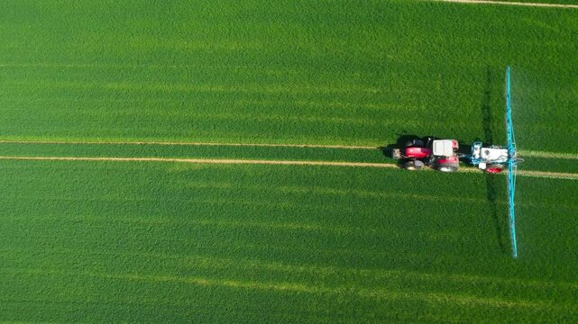 Pesticide  aplication. A tractor with chemical sprayer working on a field.