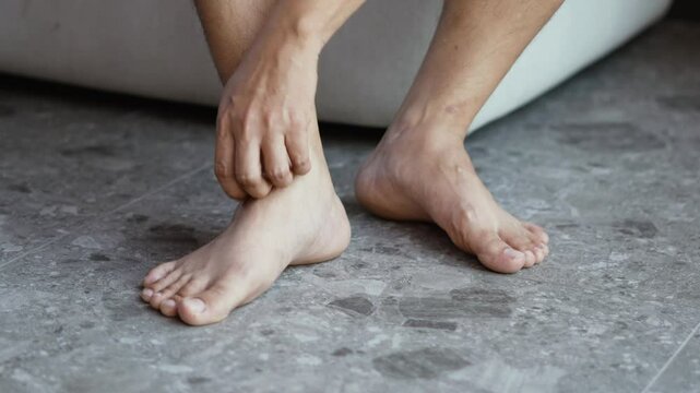 man hand scratch feet, itch foot, problem itchy skin on carpet at home, dermatitis from fungus, fungal bacterial infection, allergic reaction, eczema. Foot care concept
