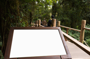 Blank white sign for text on walkway in green forest, Nature study trail, Supporting environmental...