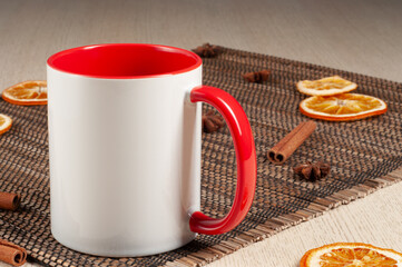 Blank two-tone 11oz mug on on the table. Mug with warm spices like cinnamon, star anise, dried...