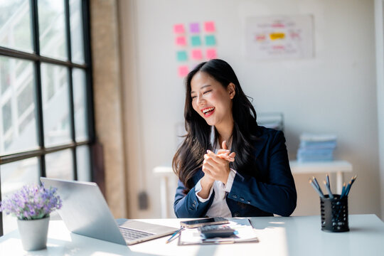 Asian manager attending online meeting and expressing joy and satisfaction