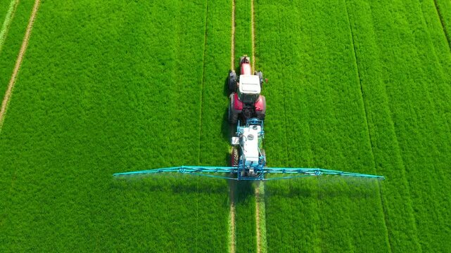 Pesticide  aplication. A tractor with chemical sprayer working on a field.